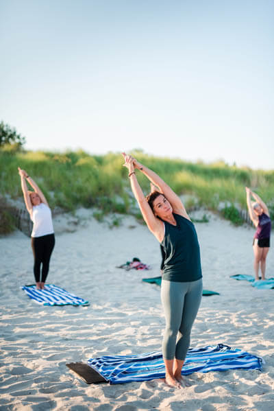 Group of women doing yoga at a beach