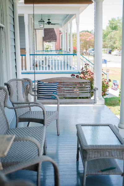 Decorated porch swing, chairs and table on a veranda