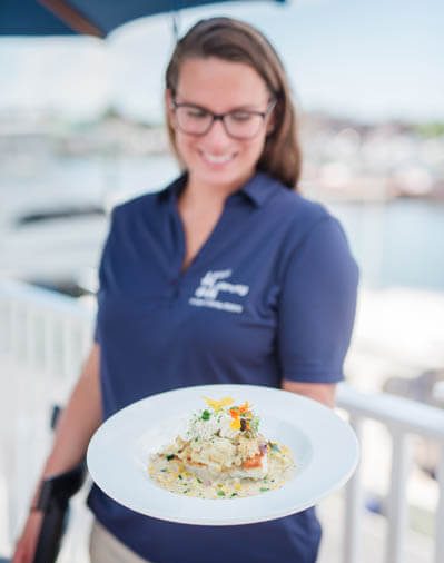 Smiling woman holding a plate of fresh made sea food