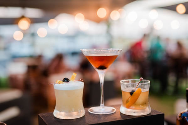 Close-up view of three colorful cocktails placed on a bar