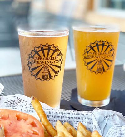Close-up view of two glasses of beer and a plate of French fries