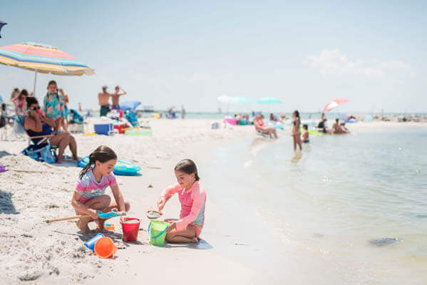 Two girls playing on the beach on a sunny day