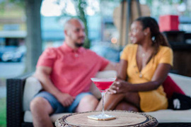 Close-up view of a cocktails placed on a table, woman and man chatting in background