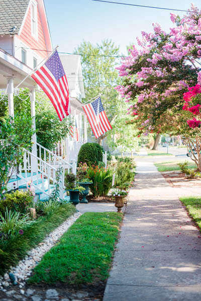 View of sidewalk, trees and a house on main street